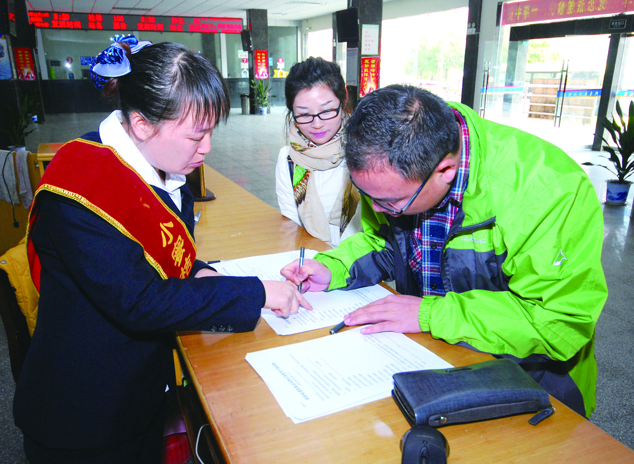 圖為洞口汽車總站站務人員在熱心為旅客服務。